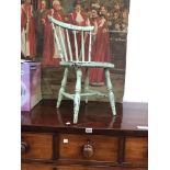 A PALE GREEN PAINTED CHILDS CHAIR WITH SIX STICK BACK AND SADDLE SEAT