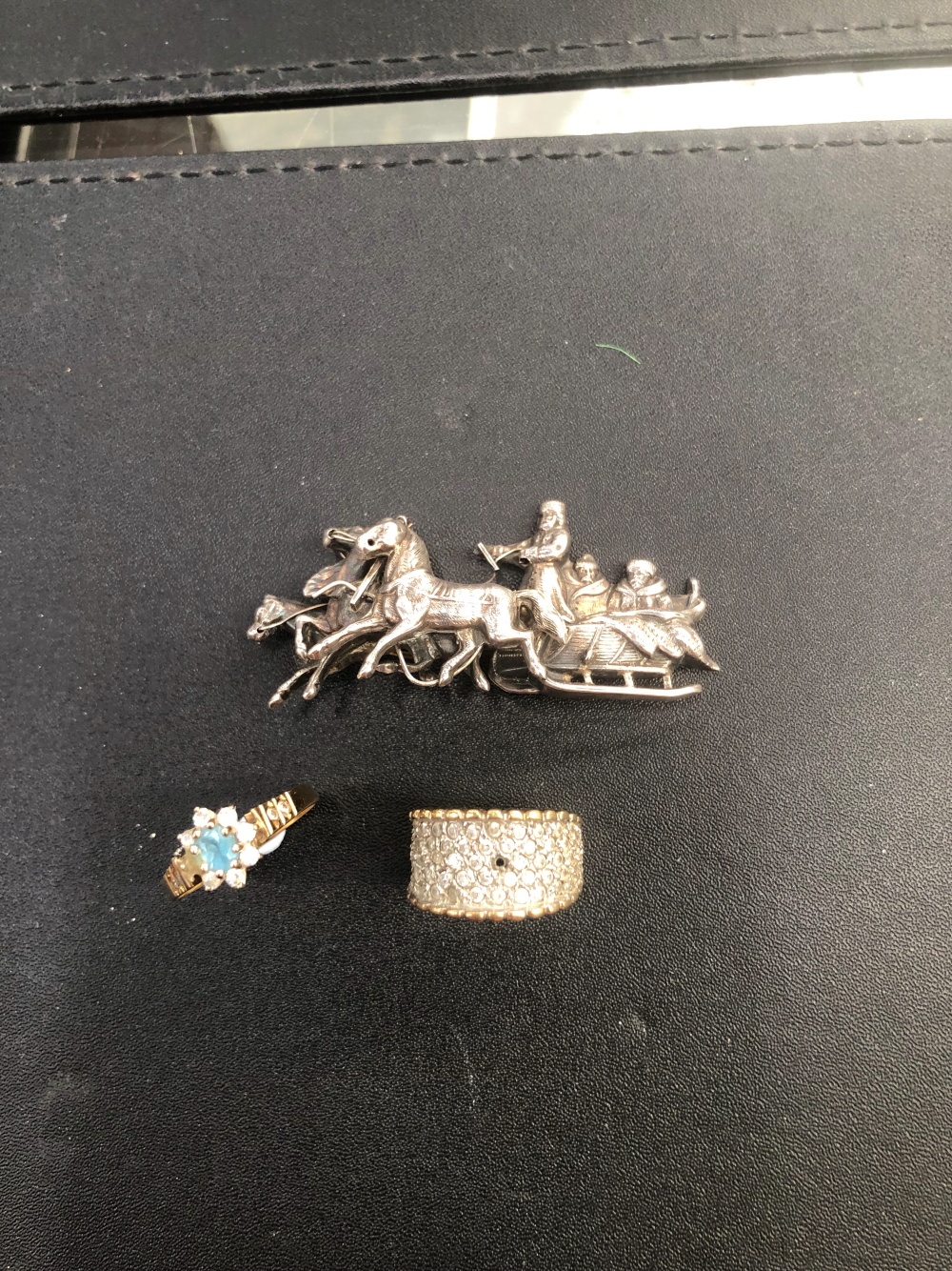 A SILVER EAST EUROPEAN BROOCH DEPICTING HORSES AND SLEIGH AND TWO 9ct GOLD DRESS RINGS.