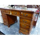 A 20th C. PEDESTAL DESK, THE LEATHER INSET TOP ABOVE A KNEEHOLE DRAWER FLANKED BY BANKS OF FOUR ON