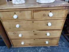 A VICTORIAN PINE CHEST OF TWO SHORT AND THREE LONG DRAWERS EACH WITH WHITE CERAMIC KNOB HANDLES ABOV