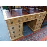 A LATE VICTORIAN PINE PEDESTAL DESK WITH LEATHER INSET TOP, THE KNEEHOLE DRAWER FLANKED BY BANKS OF