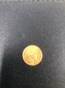 A GOLD 1860 FRENCH FIVE FRANC COIN.