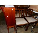 A SMALL RETRO BOOKCASE AND FOUR OAK DINING CHAIRS AND A LARGE WICKER HAMPER.