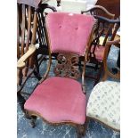 A VICTORIAN ROSEWOOD NURSING CHAIR WITH THE BUTTONED PINK VELVET TOP RAIL OVER A PIERCED AND