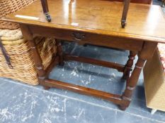 AN ANTIQUE OAK TABLE WITH SINGLE DRAWER ABOVE THE BALUSTER TURNED LEGS JOINED BY STRETCHERS ABOVE TH