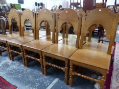 A SET OF TEN 20th C. OAK CHAIRS WITH ROUND ARCHED BACKS ABOVE SOLID SEATS AND LEGS JOINED BY