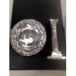 A HALLMARKED SILVER CORINTHIAN COLUMN CANDLESTICK AND AN EASTERN WHITE METAL SMALL FOOTED SALVER.