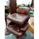 A 20th C. BROWN LEATHERETTE ARMCHAIR ROTATING ON FOUR PLYWOOD LEGS TOGETHER WITH A FOOT STOOL EN