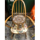 AN ERCOL STICK BACK ROCKING CHAIR TOGETHER WITH AN AFRICAN STOOL, THE SEAT WITH BEADED GIRAFFE AND