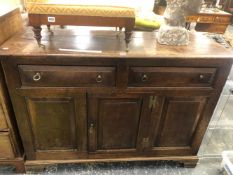 A 19th C. OAK DRESSER BASE WITH TWO DRAWERS OVER A CENTRAL DOOR FLANKED BY PANELS ABOVE BRACKET