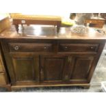 A 19th C. OAK DRESSER BASE WITH TWO DRAWERS OVER A CENTRAL DOOR FLANKED BY PANELS ABOVE BRACKET