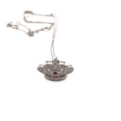 A DIAMOND AND RUBY PRINCESS CROWN PENDANT, SUSPENDED ON A CHAIN. UNHALLMARKED, STAMPED 750, AND