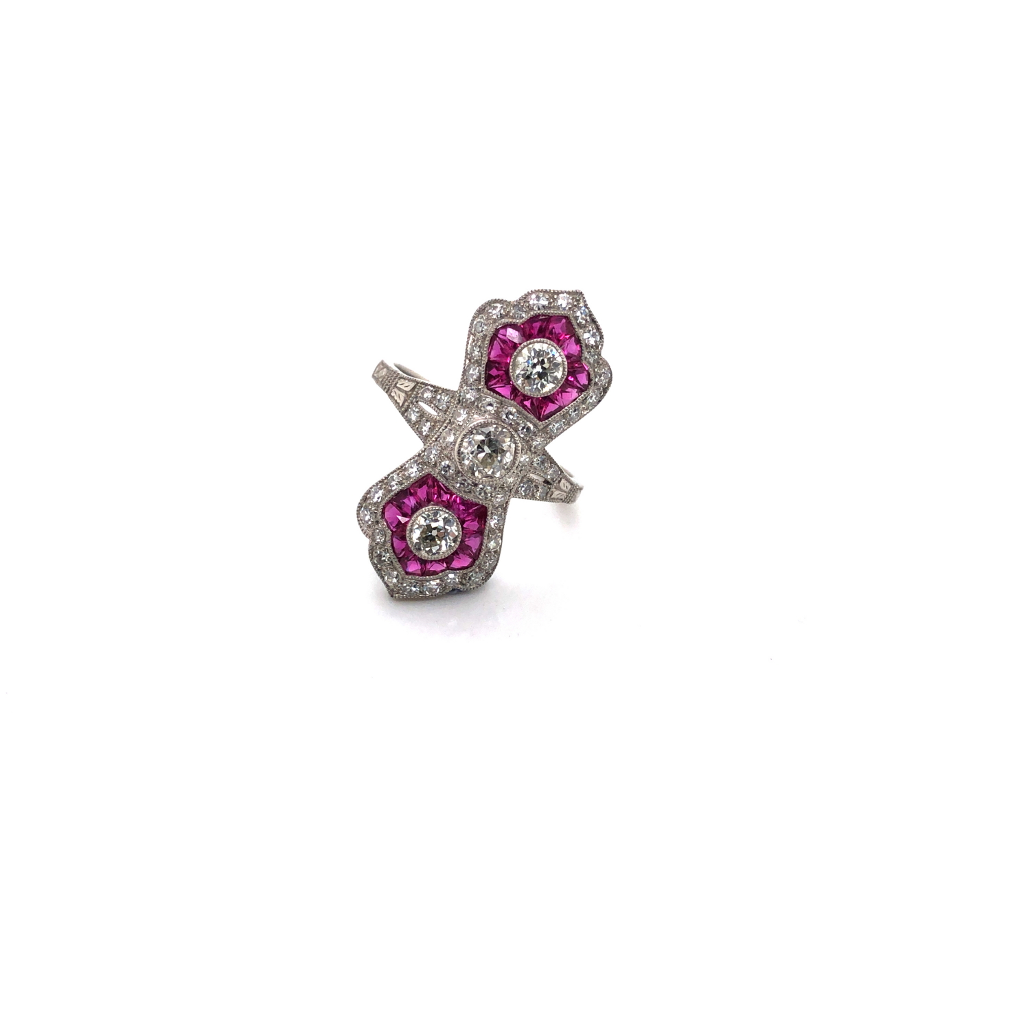 AN ART DECO STYLE RUBY AND DIAMOND COCKTAIL RING. THREE OLD CUT DIAMONDS SURROUNDED BY A FRAME OF