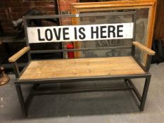 A WOODEN SEATED IRON GARDEN BENCH, THE WHITE BACK BAR INSCRIBED IN BLACK LOVE IS HERE. W 123cms.