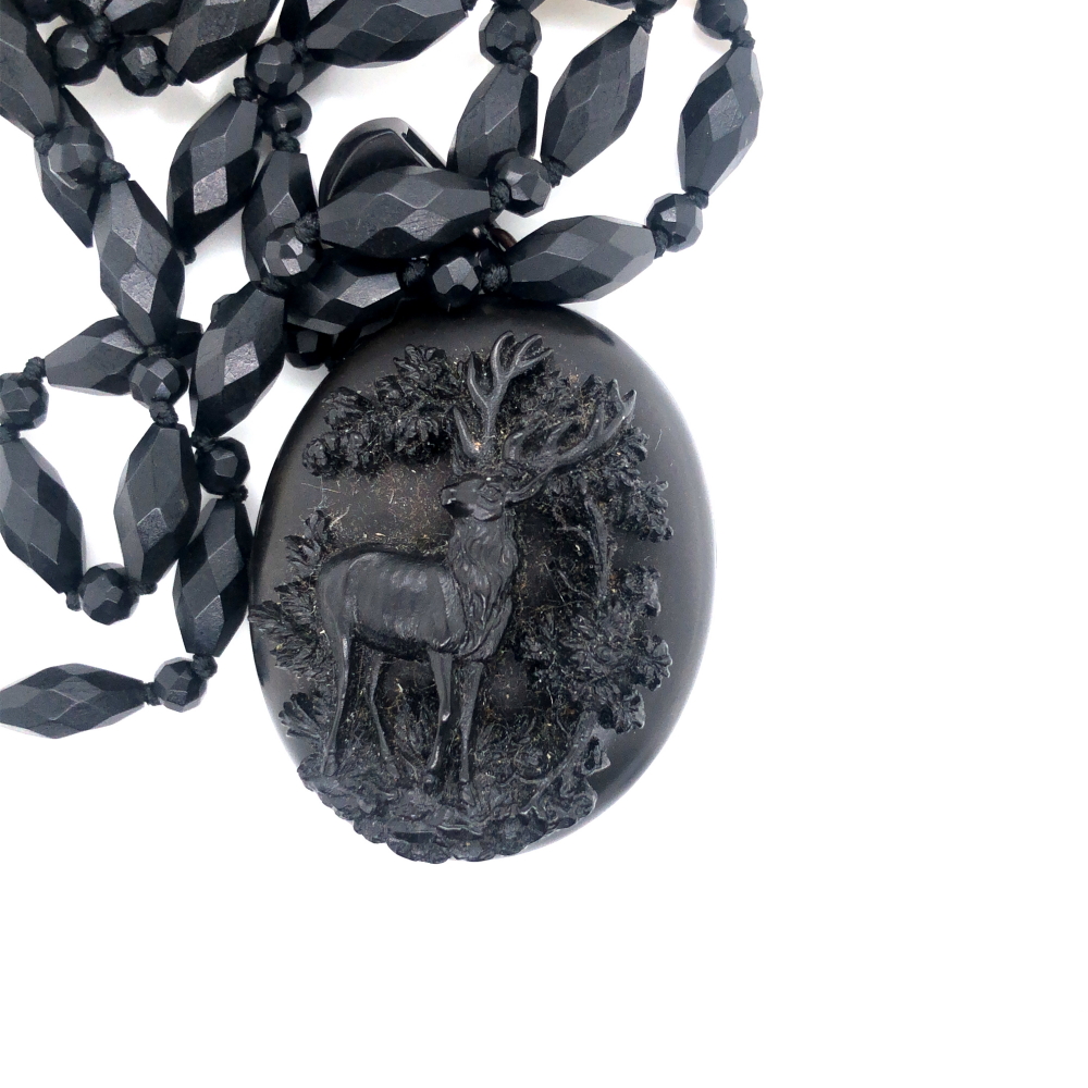 AN ANTIQUE VULCANITE MOURNING LOCKET, WITH RELIEF STAG IN WOODLAND DECORATION, THE INTERIOR WITH TWO - Image 4 of 4