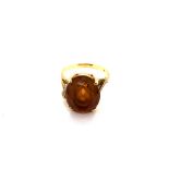 A VINTAGE OVAL ORANGE CITRINE GEMSET RING IN A RAISED FOUR CLAW SETTING. THE SHANK UNHALLMARKED WITH