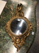 A ANTIQUE CIRCULAR CONVEX MIRROR IN A GILT ROCOCO FRAME CARVED WITH FLOWERS AND ROCAILLE. 63 x 37cms