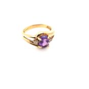 A 9CT HALLMARKED YELLOW GOLD AMETHYST AND CUBIC ZIRCONIA TWIST RING. FINGER SIZE N WEIGHT 3.30grms