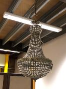 A FRENCH BEADED GLASS AND BRASS CHANDELIER, THE BUN SHAPED TOP ABOVE SLOPING SIDES TO A BOWL