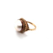 A 9ct HALLMARKED YELLOW GOLD GREENISH-PINK MABE PEARL RING, IN A ROPE EDGE BORDER, FINGER SIZE L.
