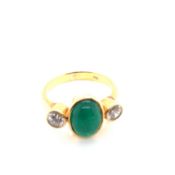 A CABOCHON SYNTHETIC EMERALD AND CUBIC ZIRCONIA THREE STONE DRESS RING. THE RING UNHALLMARKED AND