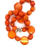 A GRADUATED BEADED AMBER NECKLACE FITTED WITH A RHINESTONE SET CLASP. LENGTH APPROX 43cms WEIGHT