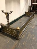 A 19th C. IRON FIRE KERB WITH FIRE IRON RESTS AND BRASS BOSSES RAISED ABOVE THE PIERCED FLORAL