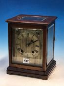 A GLAZED MAHOGANY CASED WINTERHALDER AND HOFMEIER CLOCK CHIMING ON COILED RODS, THE SILVERED DIAL