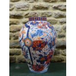 A LARGE JAPANESE IMARI RIBBED OVOID JAR PAINTED WITH CHERRY TREES IN BLOSSOM ALTERNATING WITH PHOENI