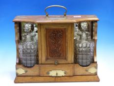 AN EARLY 20th C. OAK TWO BOTTLE TANTALUS WITH CENTRAL FLORAL CARVED CUPBOARD FLANKED BY THE MIRROR