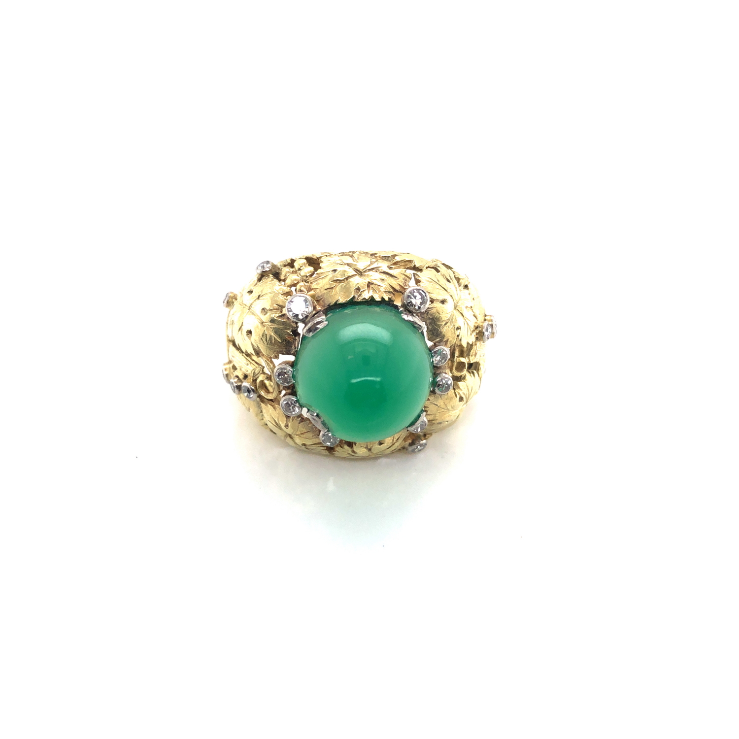 A CHRYSOPRASE DOMED CABOCHON AND ROUND BRILLIANT CUT DIAMOND FOLIATE BOMBE RING. THE CABOCHON APPROX