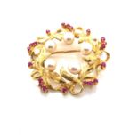 A CULTURED PEARL AND RUBY WREATH BROOCH. THE OUTER LEAVES VARIOUSLY SET WITH TWENTY ROUND
