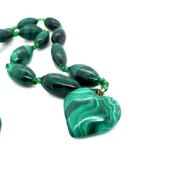 A GRADUATED MALACHITE BEADED NECKLACE SUSPENDING A MALACHITE HEART PENDANT, TOGETHER WITH AN