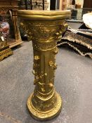 A GILT PLASTER COLUMNAR PEDESTAL WITH THREE BRACKETS BELOW THE ROUND TOP AND ABOVE ROSES IN RELIEF