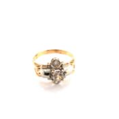 A VINTAGE DIAMOND AND MOISSANITE RING. THE CENTRAL DIAMOND ACCENTED BY A FURTHER DIAMOND AND ONE