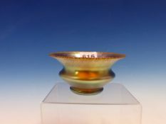 A TIFFANY STYLE IRIDESCENT GLASS BOWL, THE RIM FLARED ABOVE A DISC RINGED BODY AND CIRCULAR FOOT.