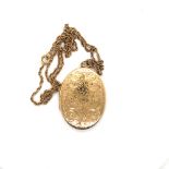 A ROPE TWIST CHAIN SUSPENDING AN OVAL PORTRAIT LOCKET WITH ENGRAVED DECORATION. THE CHAIN UNMARKED
