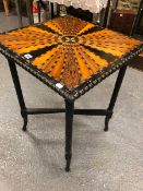 AN ANTIQUE CEYLONESE COLONIAL EBONY TABLE, THE TOP INLAID WITH VEINS OF SPECIMEN WOODS RADIATING ABO