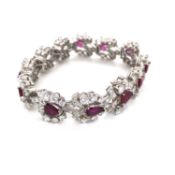 AN ART DECO STYLE RUBY AND DIAMOND COCKTAIL BRACELET. THE BRACELET CONSISTING OF TWELVE ARTICULATING