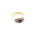 AN 18ct HALLMARKED (MARKS RUBBED) RUBY AND DIAMOND RING. THE CENTRAL OVAL RUBY APPROX MEASUREMENTS