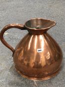 A VICTORIAN COPPER SPIRIT MEASURE, THE JUG WITH A BRAZED SEAM BELOW THE HANDLE. H 35cms.