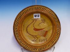 A SLIP WARE DISH DATED 1733, THE STRAW COLOURED SLIP SCRATCHED THROUGH TO THE RED CLAY BODY BELOW