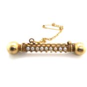 AN ANTIQUE SEED PEARL BAR BROOCH COMPLETE WITH SAFETY CHAIN, UNHALLMARKED AND ASSESSED AS 22ct