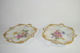 Pair of Continental porcelain dishes decorated in Meissen style of flowers within gilt borders, 30cm