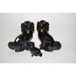 Group of three black Staffordshire spaniels comprising a large pair and smaller model, all with gilt