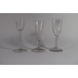 Group of three wine glasses, 18th century, one with air twist (chips to foot), the other two with