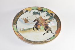 Japanese porcelain charger decorated with warriors on horseback, 38cm diam