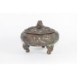Chinese bronze pot and cover on three feet, modelled in relief with dragons, the cover with