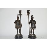 Two Roman warriors on circular bases holding candlesticks, 33cm high (2)