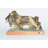 Cold cast painted table lighter depicting a spaniel carrying a pheasant in its mouth, on wooden